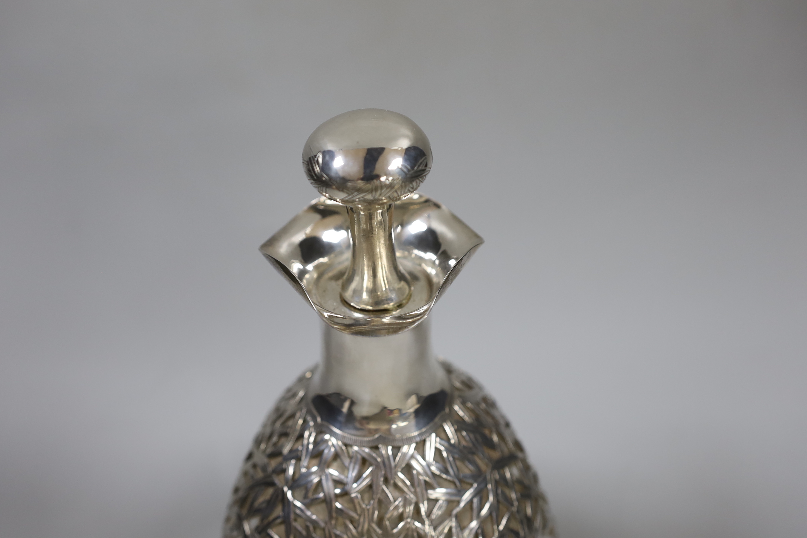 An early 20th century Chinese white metal mounted glass Haig decanter and stopper, Hong Kong, height 26.3cm.